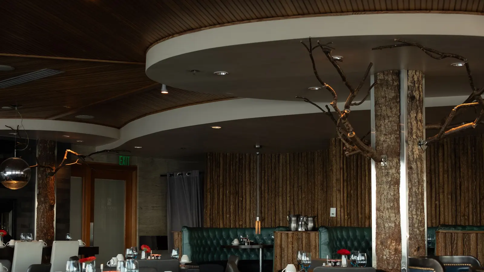Une salle de restaurant vide, tables dressées et banquettes inoccupées